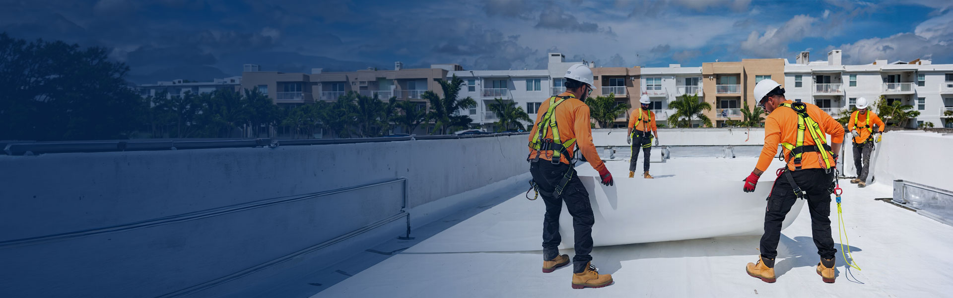 HOA roofing crew installing TPO membrane on a Miami multi-unit community building